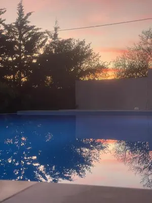 a reflection of the sunset in a pool at Eco Lodge Villa das Alfarrobas com Piscina in Algoz