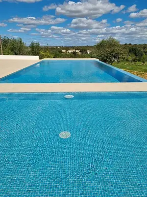 a large swimming pool with blue tiles on it at Eco Lodge Villa das Alfarrobas com Piscina in Algoz