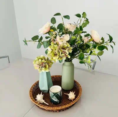 two vases with flowers and a candle on a table at Amazing Ocean View Apt Steps from the Beach in Quarteira