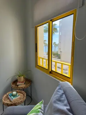 a living room with a window and a couch at Amazing Ocean View Apt Steps from the Beach in Quarteira