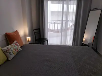 a bedroom with a large bed and a window at T2 Vista Atlantica 3 minutos da praia de Quarteira in Quarteira
