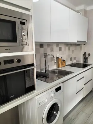 a kitchen with a washer and a sink and a microwave at T2 Vista Atlantica 3 minutos da praia de Quarteira in Quarteira