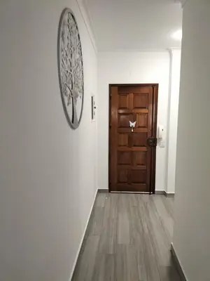a hallway with a wooden door and a wooden floor at T2 Vista Atlantica 3 minutos da praia de Quarteira in Quarteira
