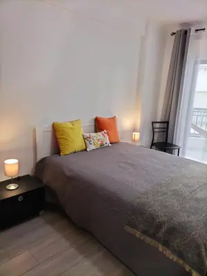 a bedroom with a bed with colorful pillows on it at T2 Vista Atlantica 3 minutos da praia de Quarteira in Quarteira