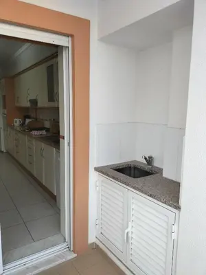 a kitchen with a sink and an open door at T2 Infante AC wifi Garagem 50m Praia in Quarteira