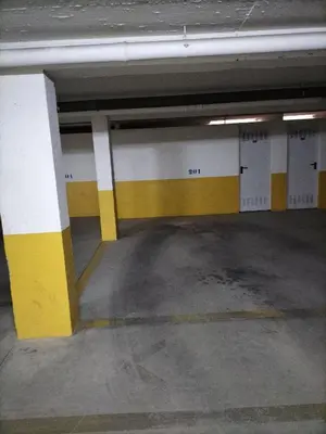 an empty parking garage with yellow and white columns at T2 Infante AC wifi Garagem 50m Praia in Quarteira