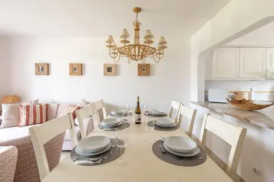 a dining room with a table with chairs and a chandelier at Moradia Olhos de Água - 3 quartos - 6 camas in Albufeira
