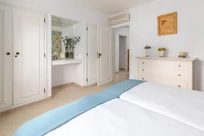 a white bedroom with a large bed and white cabinets at Moradia Olhos de Água - 3 quartos - 6 camas in Albufeira