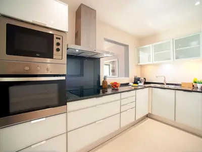 a kitchen with white cabinets and stainless steel appliances at Apartment Pine Hills Cristal by Interhome in Vilamoura