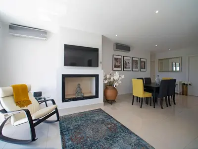 a living room with a fireplace and a dining room at Apartment Pine Hills Ambar by Interhome in Vilamoura