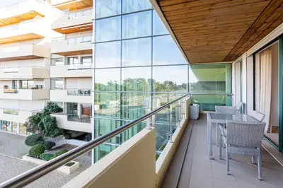 a balcony with chairs and tables on a building at Marina Vilamoura - Aquamar 201 - By Vilamoura Sun in Quarteira