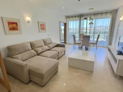 a living room with a couch and a table at Marina Vilamoura - Aquamar 201 - By Vilamoura Sun in Quarteira