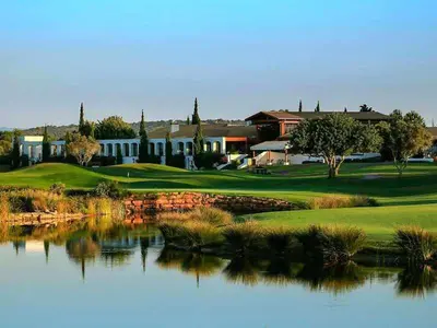 a golf course with a pond in front of a building at Marina Vilamoura - Aquamar 009 - By Vilamoura Sun in Loulé