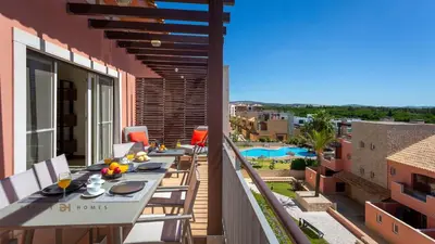 a balcony with a table and chairs on a building at Greice Homes-2 bedroom penthouse Vilamoura in Quarteira