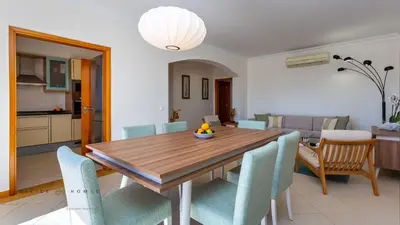 a dining room with a wooden table and chairs at Greice Homes-2 bedroom penthouse Vilamoura in Quarteira