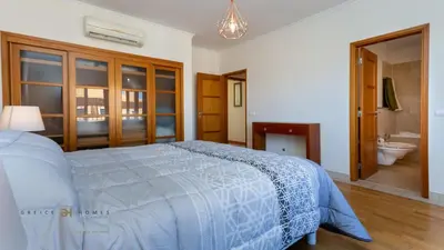 a bedroom with a bed and a bathroom with a sink at Greice Homes-2 bedroom penthouse Vilamoura in Quarteira