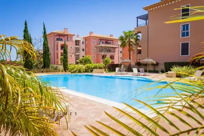 a large swimming pool in front of a building at Greice Homes-2 bedroom penthouse Vilamoura in Quarteira