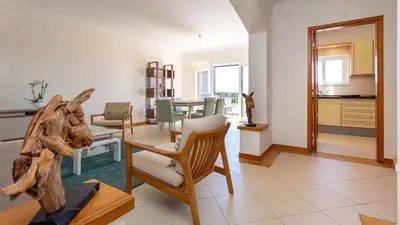 a living room with a table and a dining room at Greice Homes-2 bedroom penthouse Vilamoura in Quarteira