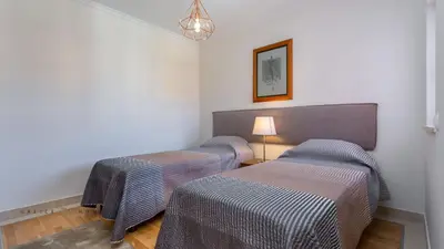 a room with two beds and a table with a lamp at Greice Homes-2 bedroom penthouse Vilamoura in Quarteira