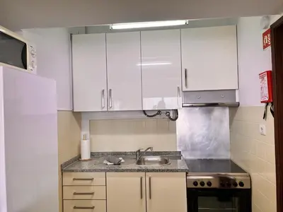 a kitchen with white cabinets and a sink at Julias Beach Retreat in Quarteira