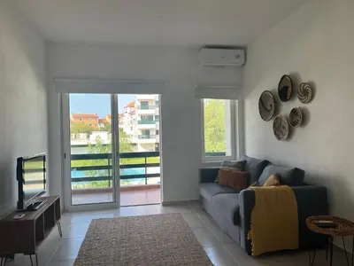 a living room with a blue couch and a television at Vilamoura Neptuno Apartment in Vilamoura