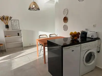 a kitchen with a washing machine and a table at Vilamoura Neptuno Apartment in Vilamoura