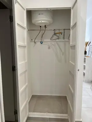 a walk in closet with white cabinets and a light at Vilamoura Neptuno Apartment in Vilamoura