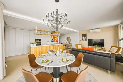 a dining room and living room with a table and chairs at Luxury 3-Bed Penthouse with Ocean Views, Terrace & Pool in Quarteira