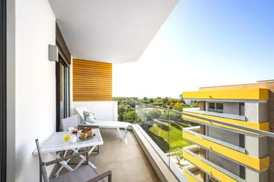 a room with a balcony with a table at Luxury 3-Bed Penthouse with Ocean Views, Terrace & Pool in Quarteira