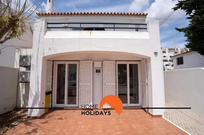 a white house with an open door with an orange arrowoting home holidays at #265 Charming Villa Sam in Albufeira