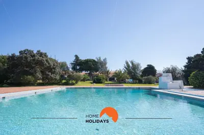 a large swimming pool with a sign that says home holidays at #265 Charming Villa Sam in Albufeira