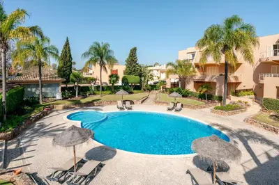 a swimming pool with chairs and umbrellas at Coastal Golf by Seareen in Vilamoura