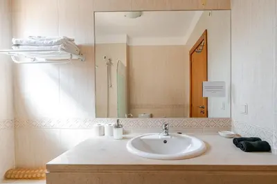 a bedroom with a bed and a dresser and a mirror at Coastal Golf by Seareen in Vilamoura