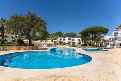 a swimming pool in a resort with buildings in the background at Balaia Golf Poolside Retreat - Superior 2 bed villa in Albufeira