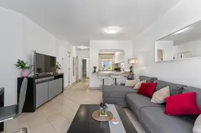 a living room with a couch and a kitchen at Balaia Golf Poolside Retreat - Superior 2 bed villa in Albufeira