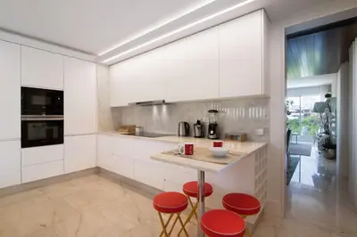 a kitchen with white cabinets and red stools at Sweet Home Albufeira in Albufeira