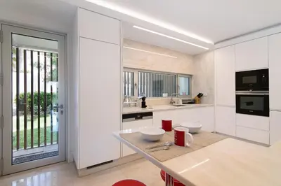 a kitchen with white cabinets and a large window at Sweet Home Albufeira in Albufeira