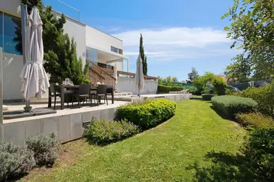 a patio with a table and an umbrella in a yard at Sweet Home Albufeira in Albufeira