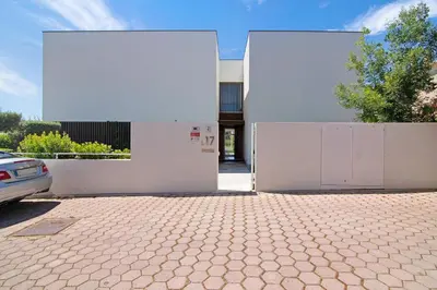 a building with two white doors and a driveway at Sweet Home Albufeira in Albufeira