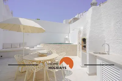 a dining room with a table and an umbrella at #128 Number 10 Villa by Home Holidays in Albufeira