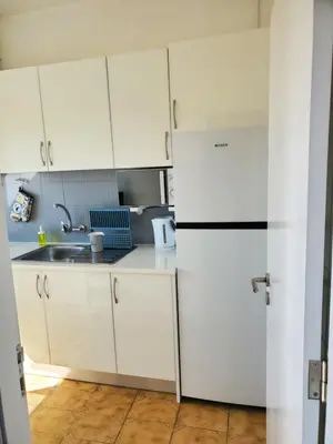 a white kitchen with a sink and a refrigerator at L&J Ocean View Apartment in Albufeira
