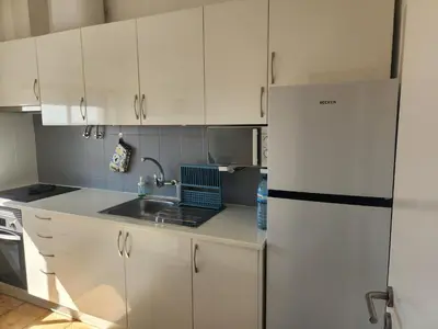 a kitchen with white cabinets and a white refrigerator at L&J Ocean View Apartment in Albufeira