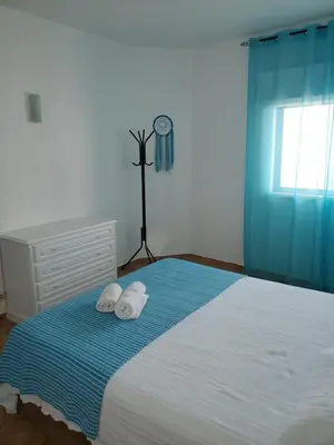 a bedroom with a bed with two pillows and a clock at L&J Ocean View Apartment in Albufeira