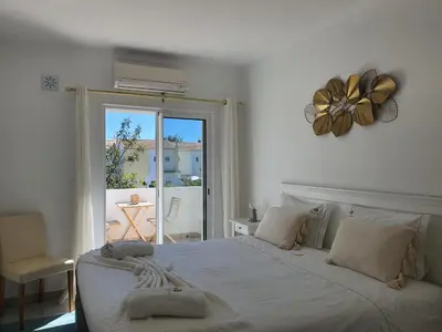 a bedroom with a large white bed with a window at Real Village in Quarteira