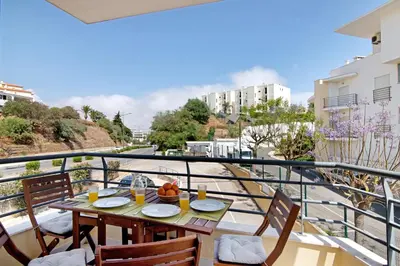 a table on a balcony with a view of a street at Flat with Pool Marina and Sea View in Albufeira