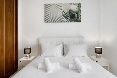 a bedroom with a white bed with white pillows at Flat with Pool Marina and Sea View in Albufeira