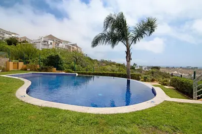 a swimming pool with a palm tree in a yard at Flat with Pool Marina and Sea View in Albufeira