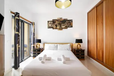 a bedroom with a large white bed with two night stands at Flat with Pool Marina and Sea View in Albufeira