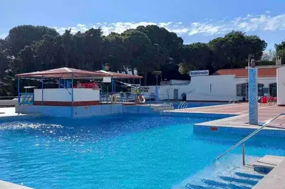 a swimming pool with blue water in front of a building at Studio with great sea view, near the beach, with AC and pools in Albufeira