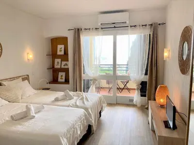 a hotel room with two beds and a balcony at Studio with great sea view, near the beach, with AC and pools in Albufeira